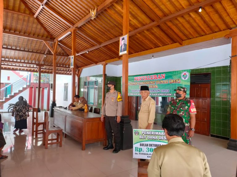 Bhabinkamtibmas Polsek Sanankulon Melaksanakan Pengamanan Penyaluran Bantuan Kepada Masyarakat Desa Sekaligus Himbauan Prokes.