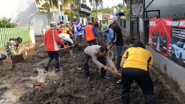 Sinergitas Polres Batu Bersama TNI dan Warga Bersihkan Lumpur Akibat Banjir Lalulintas Kembali Lancar