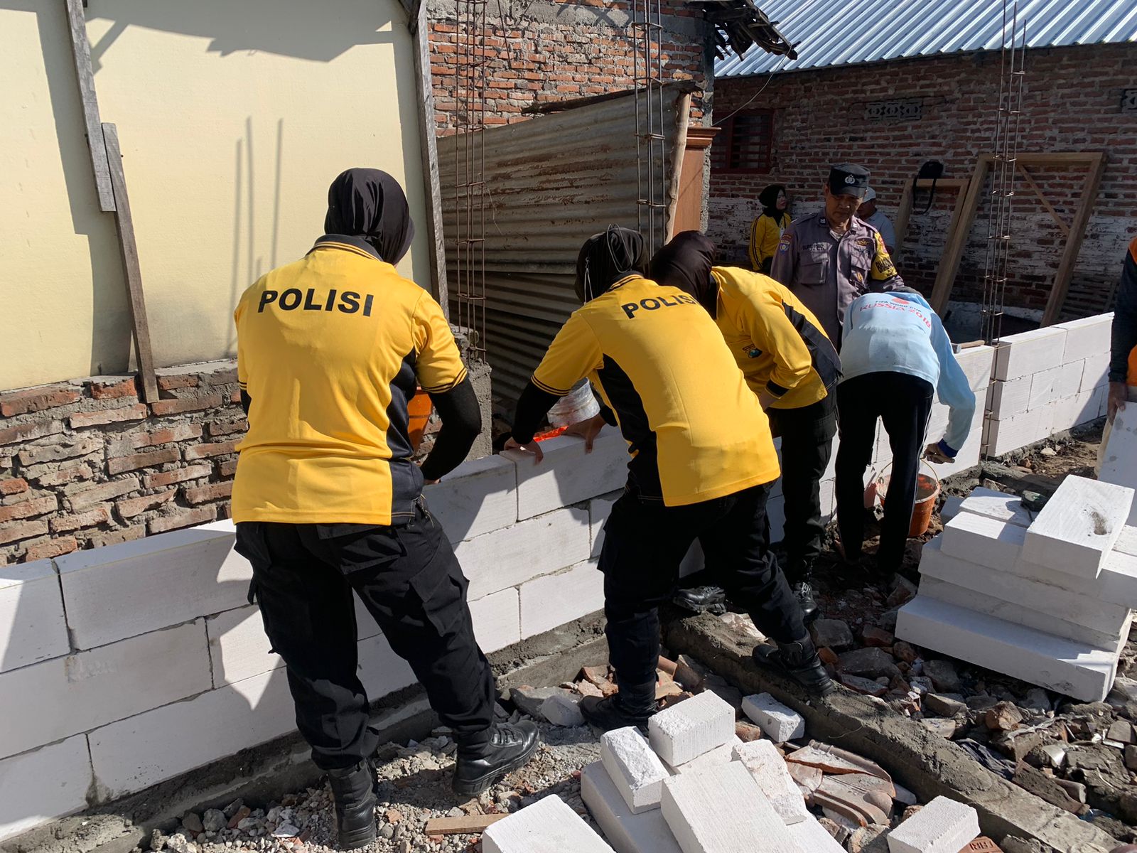 Tak Mau Ketinggalan, Anggota Polwan Polres Nganjuk Turut Andil Dalam Program Bedah Rumah